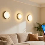 Aplice LED moderne pe perete într-un living stylish, persoană ajustând lumina cu smartphone-ul